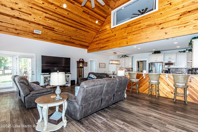 living room with dark hardwood / wood-style floors, wooden walls, high vaulted ceiling, a water view, and wooden ceiling