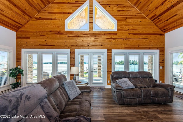 living room with wooden walls, wood ceiling, dark wood-style flooring, a water view, and high vaulted ceiling