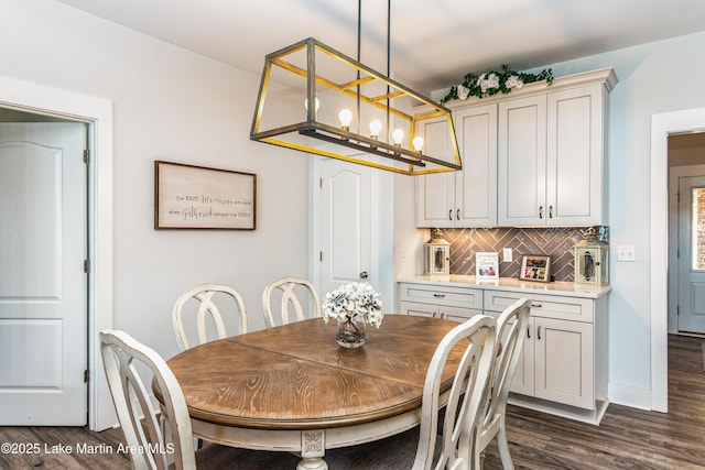 dining area with dark wood-type flooring and a chandelier