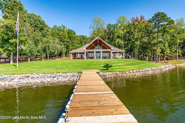 view of dock with a yard and a water view