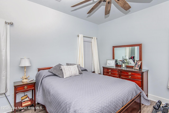 bedroom with ceiling fan, light wood-style flooring, and baseboards