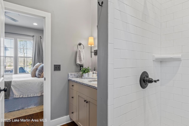 bathroom featuring a tile shower, vanity, and hardwood / wood-style floors