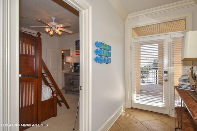 doorway featuring ceiling fan, light tile patterned flooring, and ornamental molding