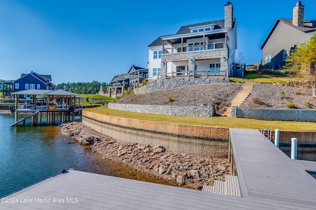 view of dock featuring a lawn and a water view