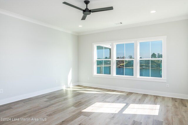 spare room featuring light wood-type flooring, ceiling fan, and ornamental molding