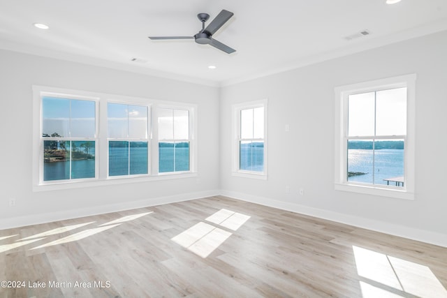 spare room featuring ornamental molding, a water view, ceiling fan, and light hardwood / wood-style floors