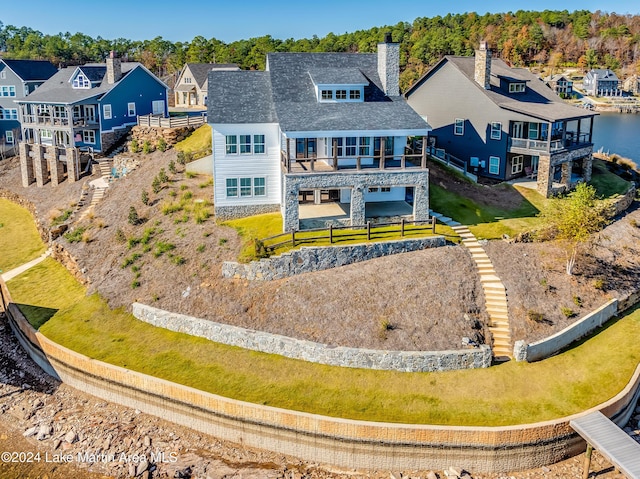 rear view of house featuring a balcony and a water view