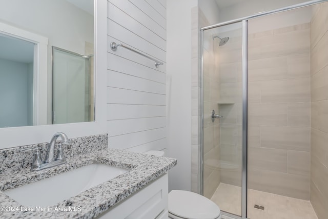 bathroom featuring vanity, toilet, and an enclosed shower