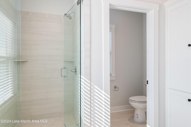 bathroom featuring toilet and an enclosed shower