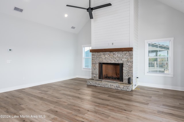 unfurnished living room with hardwood / wood-style floors, ceiling fan, a fireplace, and high vaulted ceiling