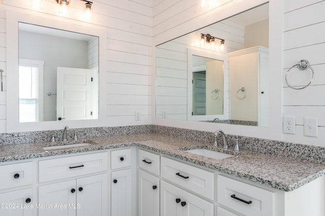 bathroom featuring vanity and wood walls