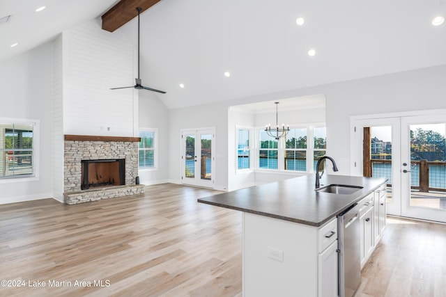 kitchen featuring french doors, sink, high vaulted ceiling, white cabinetry, and plenty of natural light