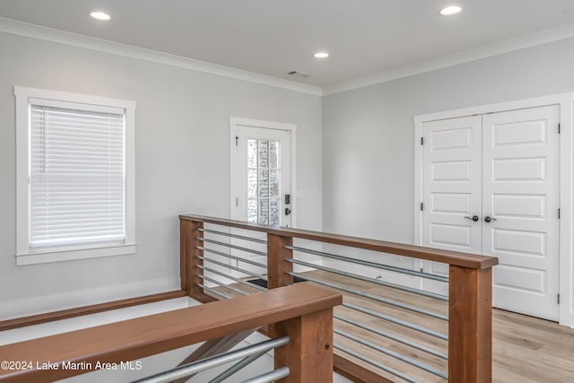 hallway with light hardwood / wood-style floors and crown molding