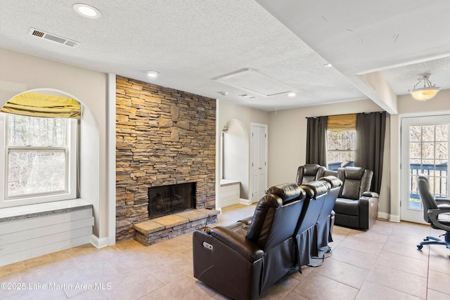 1449 Seals St, Auburn, AL 36879 - living area with visible vents, a fireplace, a textured ceiling, and light tile patterned flooring