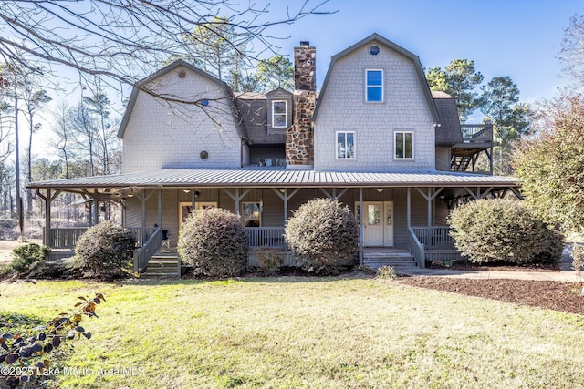 view of front of property with a porch, a front yard, a chimney, and a gambrel roof