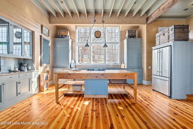 unfurnished dining area with beam ceiling and light wood-type flooring