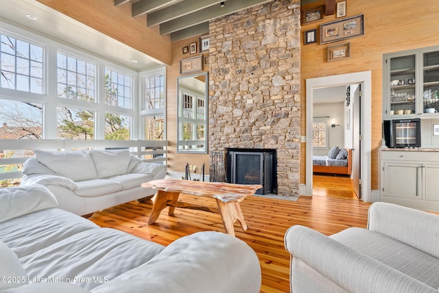 living room with hardwood / wood-style flooring, a fireplace, wooden walls, and a high ceiling