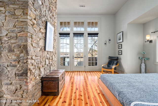 bedroom with hardwood / wood-style floors and access to exterior