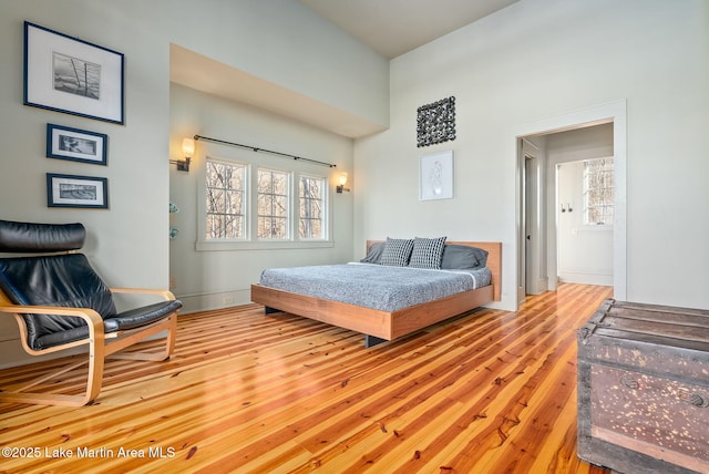 bedroom with light hardwood / wood-style flooring and a high ceiling