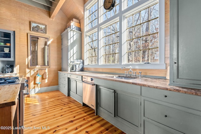 kitchen featuring sink, wood walls, gray cabinetry, light hardwood / wood-style flooring, and beamed ceiling