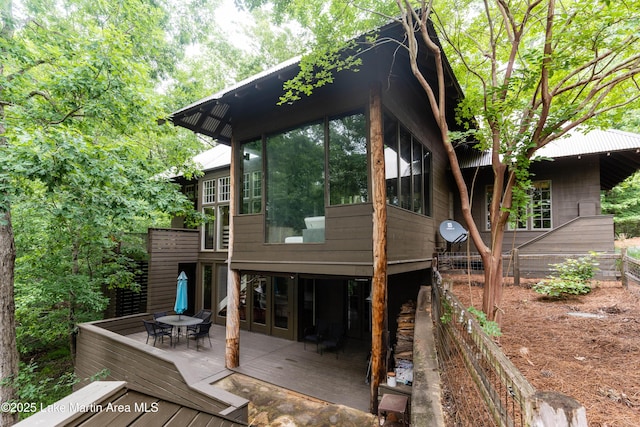 rear view of property with outdoor dining space and a wooden deck