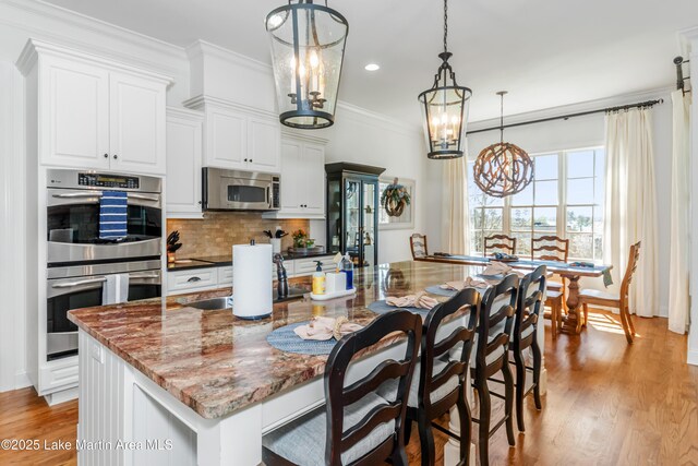 180 Glynmere Dr, Alexander City, AL 35010 - kitchen with a notable chandelier, a sink, appliances with stainless steel finishes, light wood-style flooring, and ornamental molding
