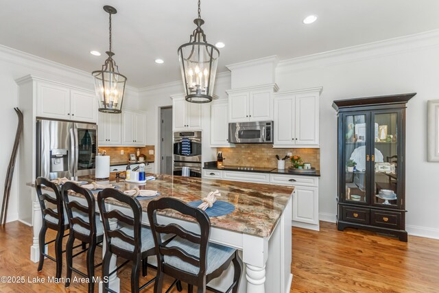 180 Glynmere Dr, Alexander City, AL 35010 - kitchen featuring a chandelier, a kitchen bar, light wood-type flooring, stainless steel appliances, and ornamental molding