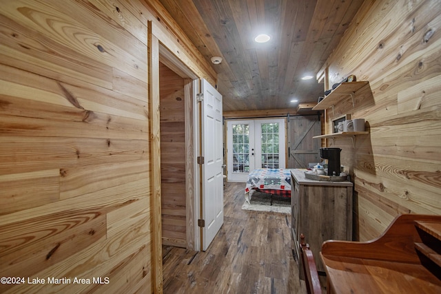 hallway featuring wood ceiling, a barn door, wood walls, and wood-type flooring