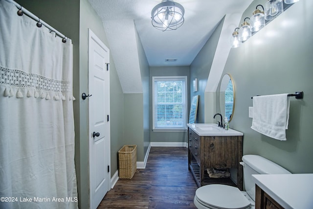 bathroom featuring lofted ceiling, toilet, a textured ceiling, vanity, and hardwood / wood-style flooring