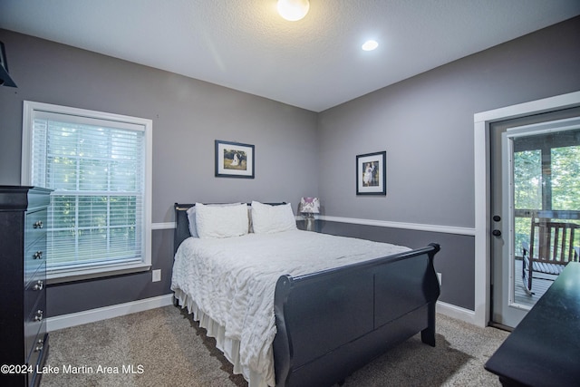 bedroom featuring carpet flooring, a textured ceiling, and access to outside