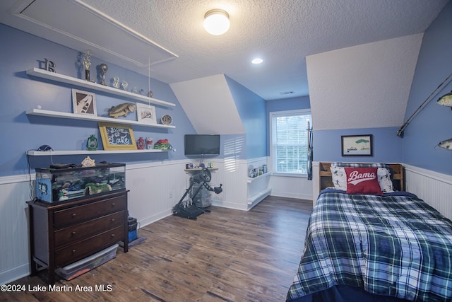 bedroom featuring a textured ceiling, dark wood-type flooring, and vaulted ceiling