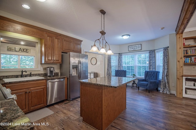 kitchen featuring plenty of natural light, a kitchen island, stainless steel appliances, and dark wood-type flooring