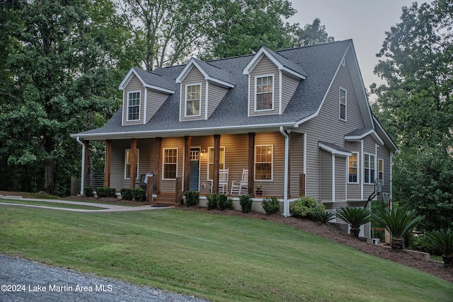 new england style home with a front lawn and covered porch