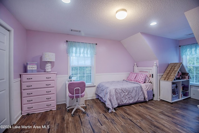 bedroom featuring multiple windows, dark wood-type flooring, and a textured ceiling