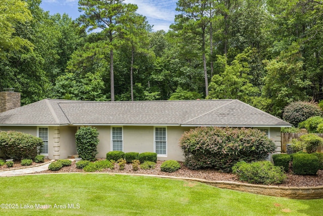 970 Raintree Dr, Alexander City, AL 35010 - ranch-style home with a shingled roof, stucco siding, a front yard, and a chimney