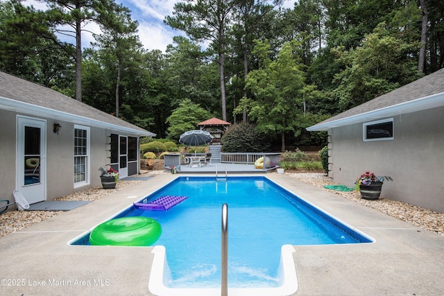 970 Raintree Dr, Alexander City, AL 35010 - swimming pool featuring view of wooded area, a patio area, and a deck