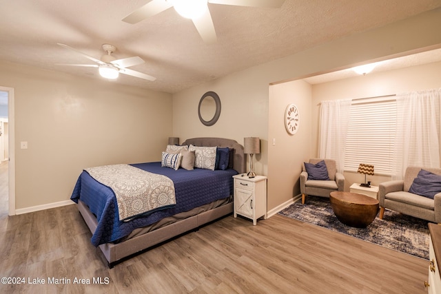 bedroom featuring wood-type flooring, a textured ceiling, and ceiling fan