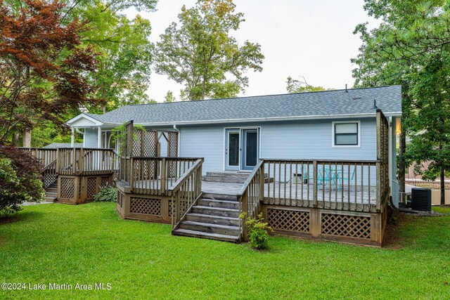 back of property with a lawn, a wooden deck, and cooling unit