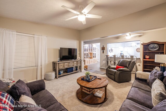 carpeted living room with ceiling fan