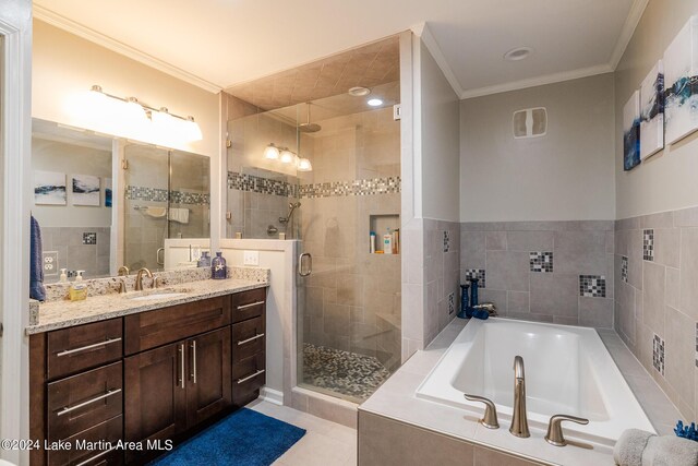 bathroom featuring shower with separate bathtub, vanity, tile patterned floors, and crown molding