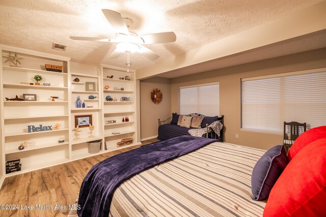 bedroom featuring wood-type flooring, a textured ceiling, and ceiling fan