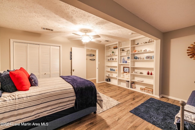 bedroom featuring a closet, ceiling fan, hardwood / wood-style floors, and a textured ceiling