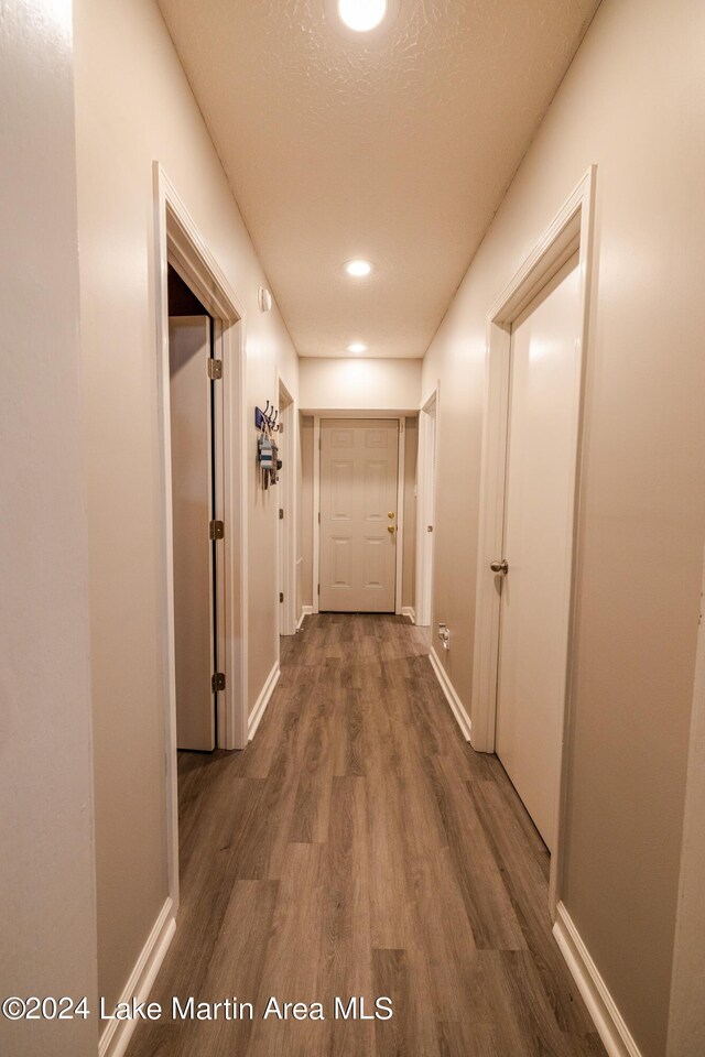 hallway featuring a textured ceiling and dark wood-type flooring