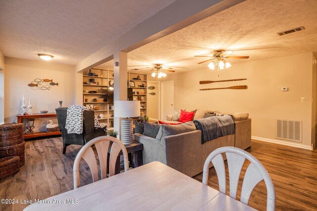 dining space with ceiling fan, hardwood / wood-style floors, and a textured ceiling