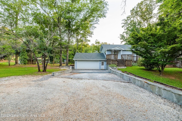 view of front facade with a front yard, a garage, an outdoor structure, and covered porch