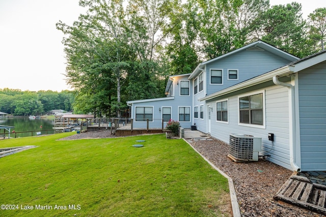 rear view of house featuring a yard, a water view, and cooling unit