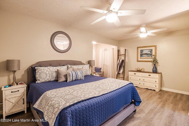 bedroom featuring wood-type flooring, a textured ceiling, and ceiling fan