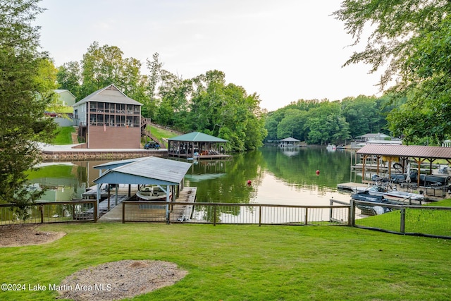 view of dock with a lawn and a water view