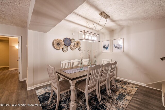 dining area with a chandelier, a textured ceiling, and dark wood-type flooring