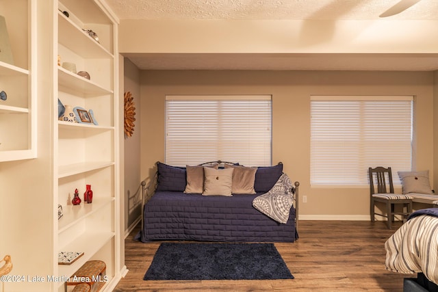 bedroom with wood-type flooring, a textured ceiling, and ceiling fan